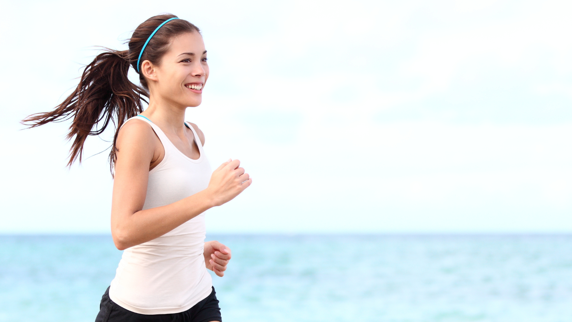 A woman running by the beach, free because of her depression treatment.